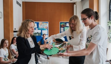 Kathrin Grau und Finn Petersen übergeben Steffi Lemke den Stapel von 350 gemalten Bildern